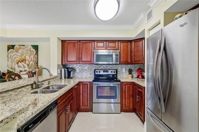 kitchen featuring visible vents, ornamental molding, a sink, appliances with stainless steel finishes, and dark brown cabinets