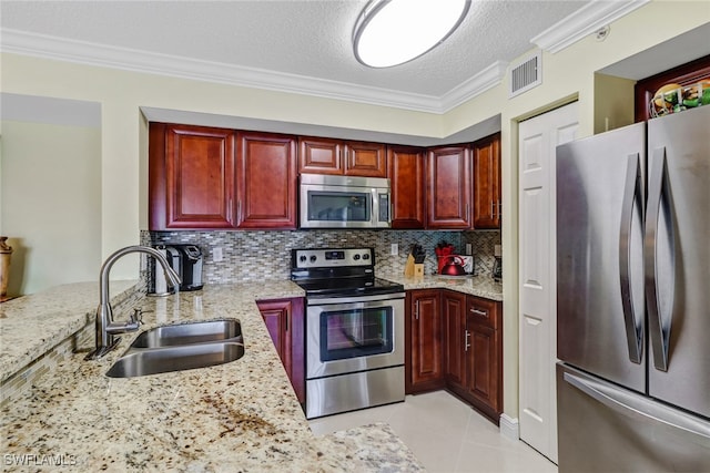 kitchen featuring visible vents, ornamental molding, a sink, appliances with stainless steel finishes, and dark brown cabinets