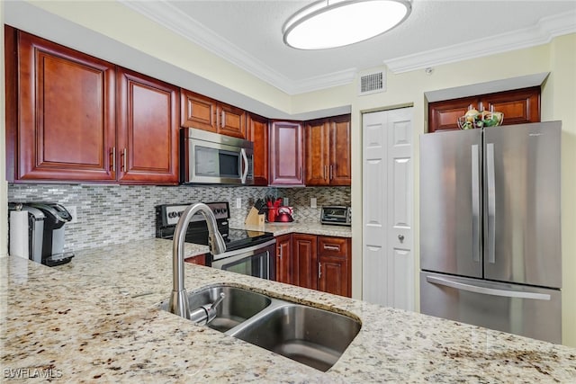 kitchen featuring light stone counters, visible vents, a sink, decorative backsplash, and appliances with stainless steel finishes