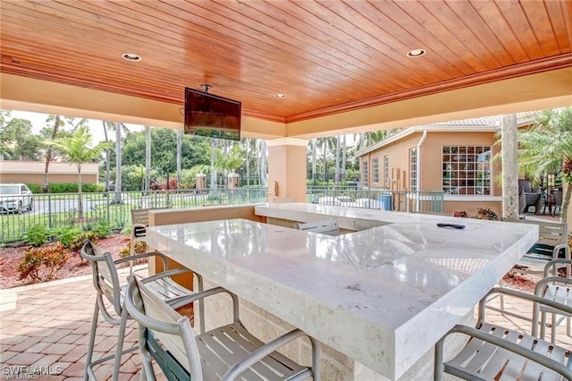 view of patio / terrace with outdoor wet bar and fence