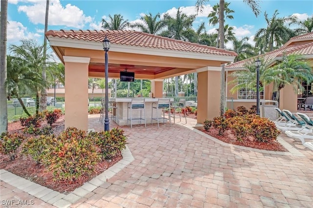 view of property's community with a gazebo, a patio area, outdoor dry bar, and fence