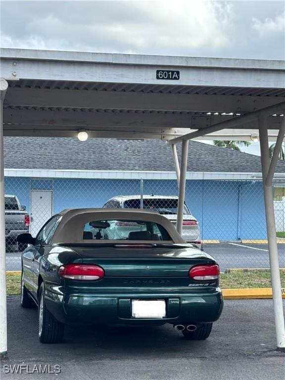 covered parking lot featuring fence