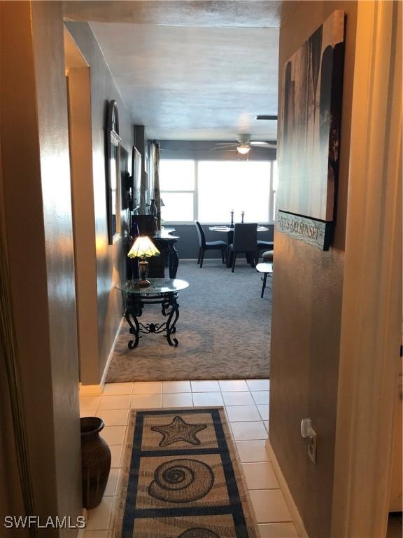 corridor featuring tile patterned flooring and carpet flooring