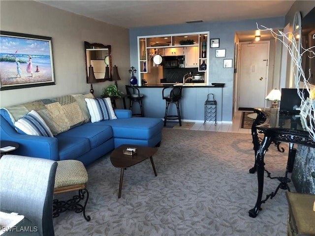 tiled living room featuring visible vents and a sink