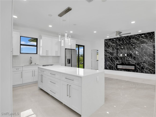 kitchen featuring stainless steel fridge with ice dispenser, light countertops, recessed lighting, white cabinets, and a sink