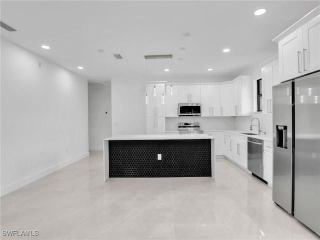 kitchen featuring a center island, light countertops, recessed lighting, stainless steel appliances, and white cabinetry