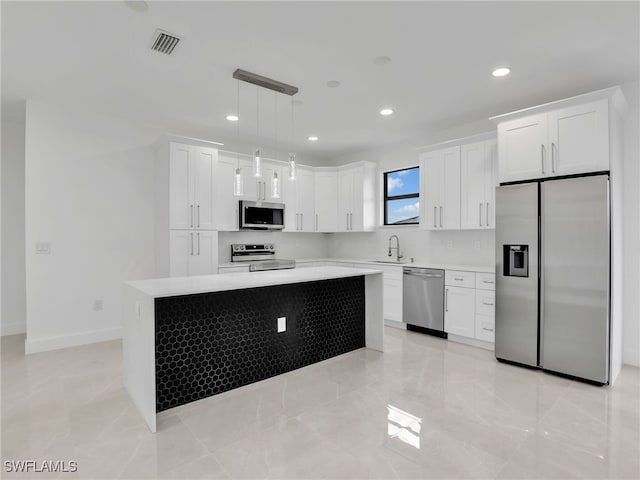 kitchen featuring visible vents, a center island, light countertops, stainless steel appliances, and a sink