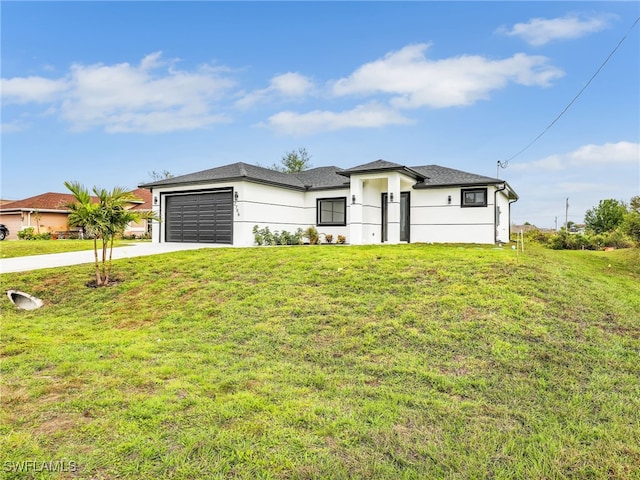 prairie-style home featuring an attached garage, concrete driveway, and a front lawn