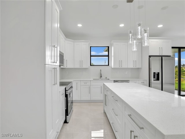 kitchen with tasteful backsplash, a kitchen island, stainless steel appliances, white cabinetry, and a sink