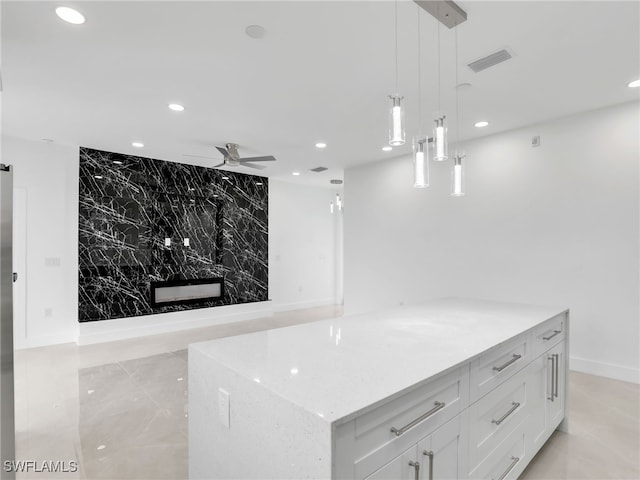 kitchen featuring light stone counters, visible vents, recessed lighting, white cabinetry, and decorative light fixtures