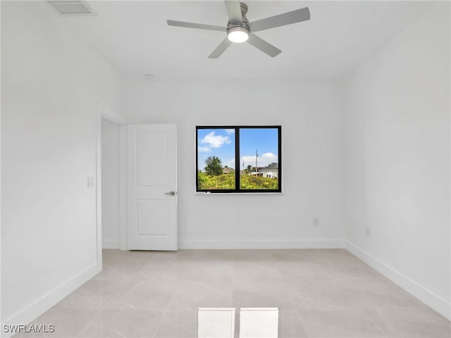 spare room featuring a ceiling fan, light tile patterned floors, visible vents, and baseboards