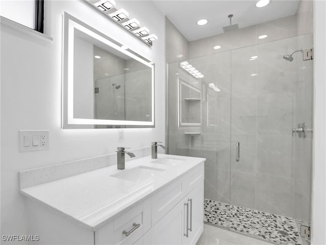 bathroom with double vanity, recessed lighting, a stall shower, and a sink