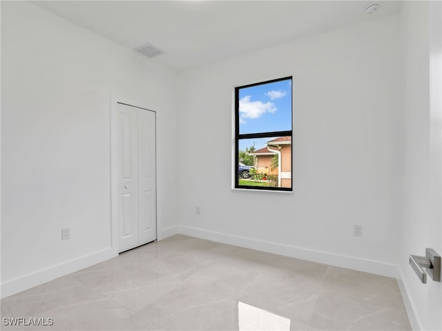 unfurnished room with baseboards and visible vents