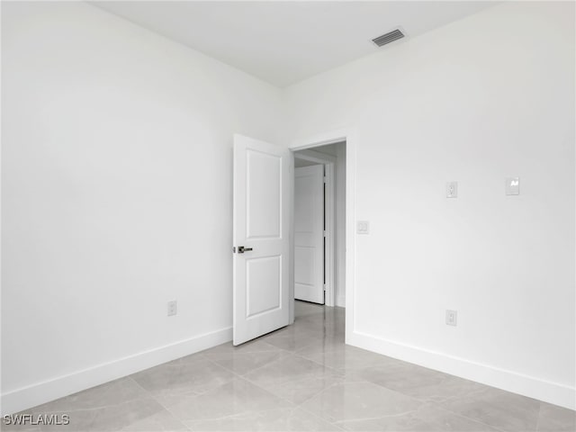 spare room featuring baseboards and visible vents