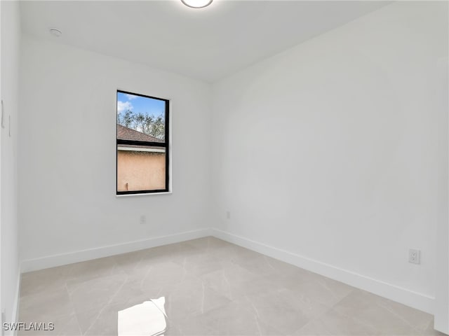 unfurnished room with baseboards