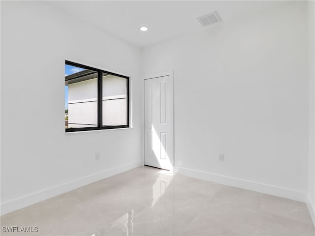 unfurnished room with recessed lighting, visible vents, and baseboards