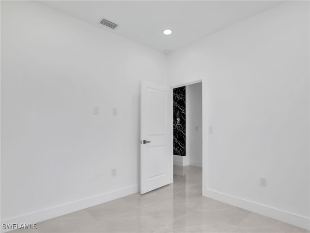 empty room featuring visible vents, recessed lighting, and baseboards