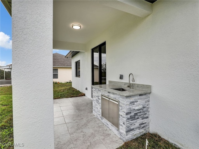 view of patio / terrace with an outdoor kitchen and a sink