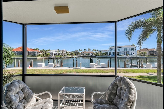 sunroom / solarium with a residential view and a water view