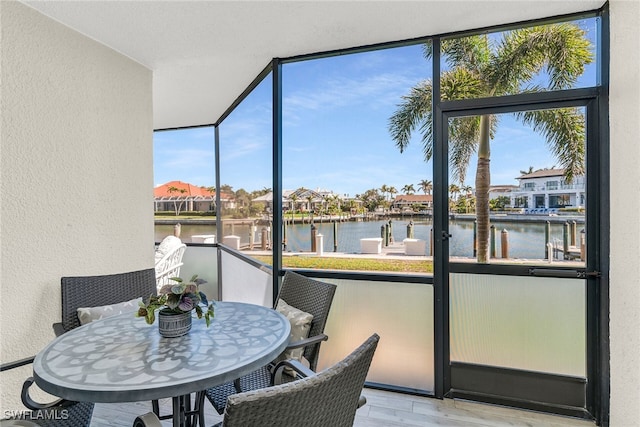 sunroom / solarium featuring a water view