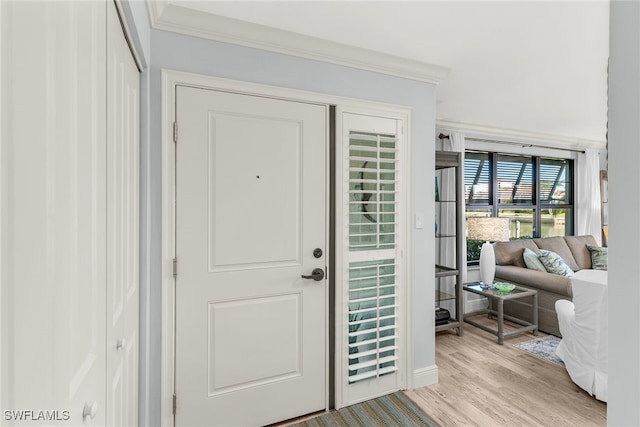 entryway featuring crown molding and light wood finished floors