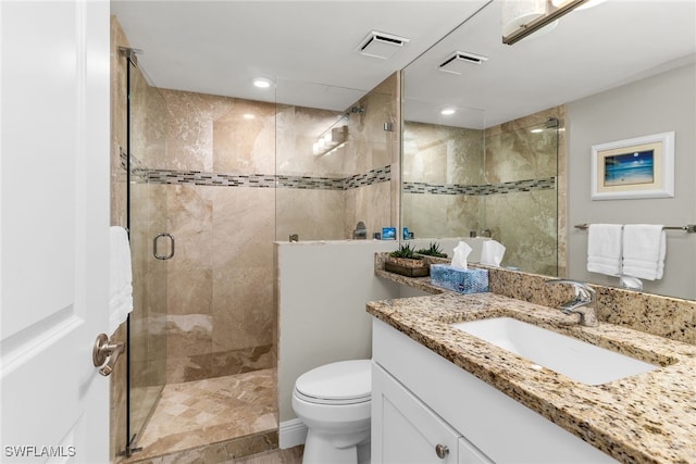 full bathroom featuring vanity, toilet, visible vents, and a stall shower