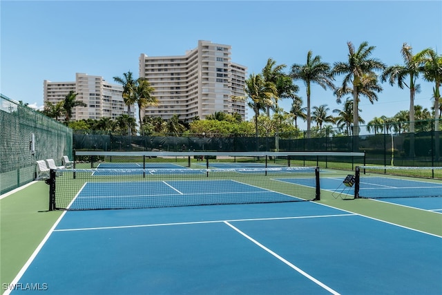 view of tennis court with community basketball court and fence