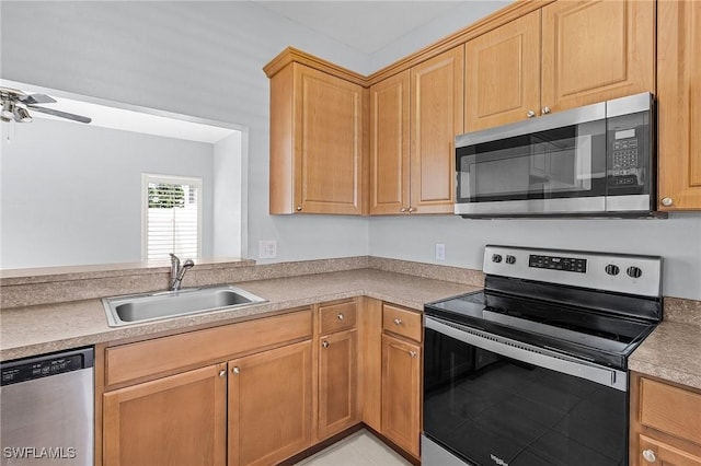 kitchen featuring light countertops, a ceiling fan, appliances with stainless steel finishes, and a sink