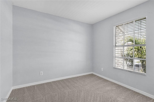 carpeted spare room featuring baseboards