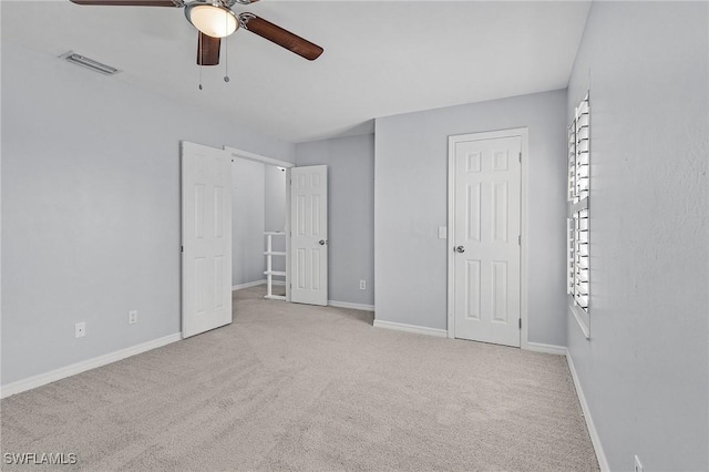 unfurnished bedroom with ceiling fan, carpet, visible vents, and baseboards