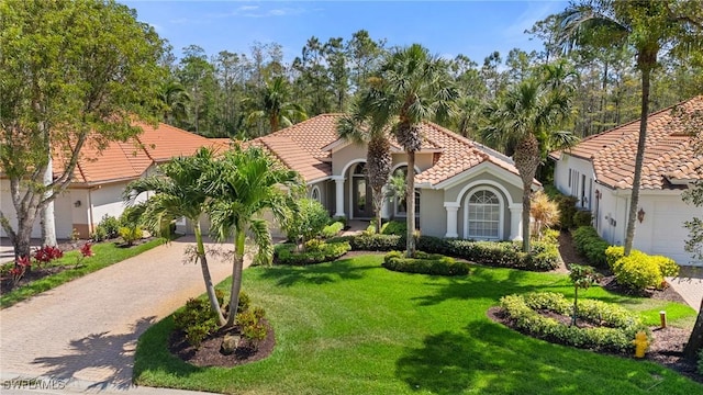 2874 Lone Pine Ln, Naples, FL 34119 - mediterranean / spanish home featuring a tiled roof, stucco siding, a front lawn, driveway, and a garage