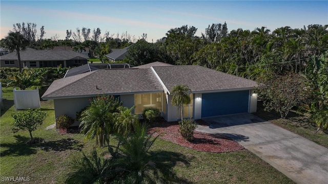 single story home with an attached garage, a shingled roof, glass enclosure, stucco siding, and driveway