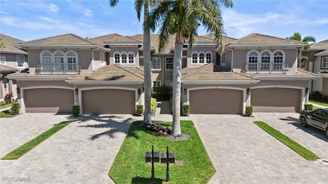 9330 Triana Ter Unit 274, Fort Myers, FL 33912 - view of front of home featuring a balcony, decorative driveway, a tile roof, and stucco siding