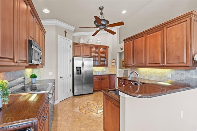 9330 Triana Ter Unit 274, Fort Myers, FL 33912 - kitchen with a ceiling fan, appliances with stainless steel finishes, a peninsula, brown cabinetry, and ornamental molding