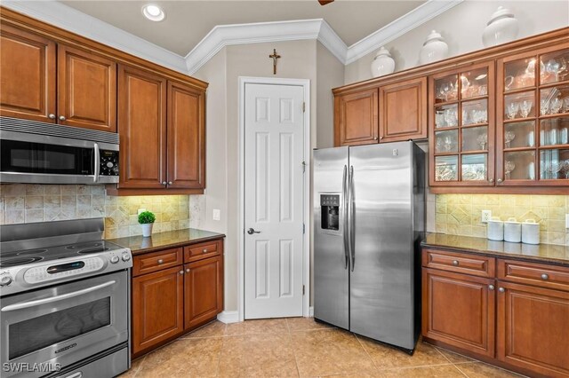 9330 Triana Ter Unit 274, Fort Myers, FL 33912 - kitchen with glass insert cabinets, ornamental molding, stainless steel appliances, and brown cabinetry