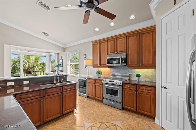 9330 Triana Ter Unit 274, Fort Myers, FL 33912 - kitchen with decorative backsplash, a sink, stainless steel appliances, and brown cabinets