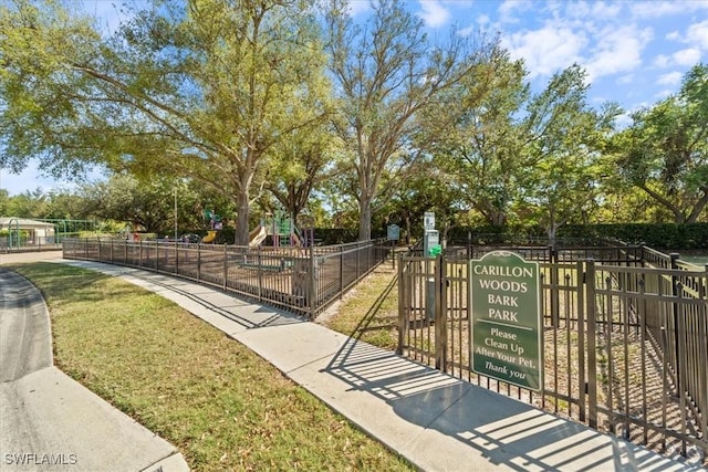 view of community with playground community, a yard, and fence