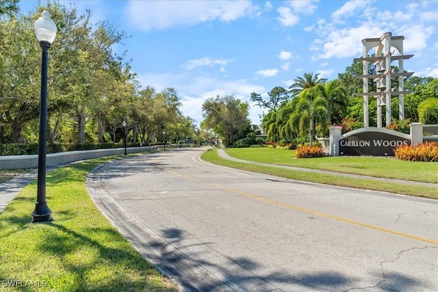 view of road with curbs, street lights, and sidewalks