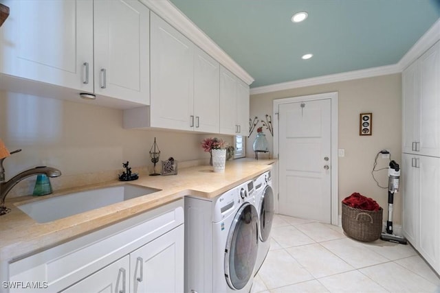 clothes washing area with light tile patterned floors, cabinet space, ornamental molding, a sink, and independent washer and dryer