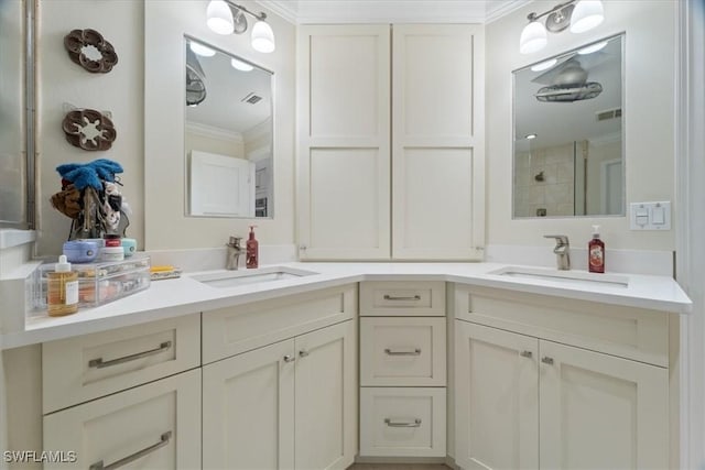 full bath with a sink, visible vents, double vanity, and crown molding