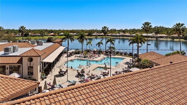 community pool with a patio area and a water view