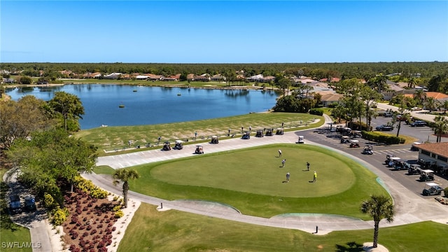 birds eye view of property with golf course view and a water view