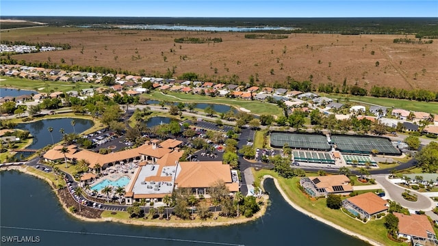 drone / aerial view with view of golf course, a water view, and a residential view