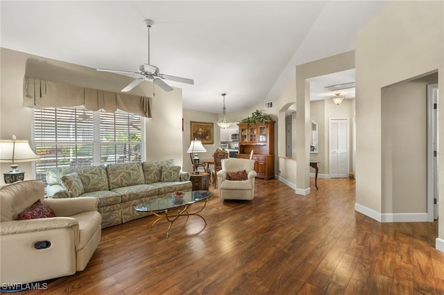 living room featuring hardwood / wood-style flooring, arched walkways, baseboards, ceiling fan, and vaulted ceiling