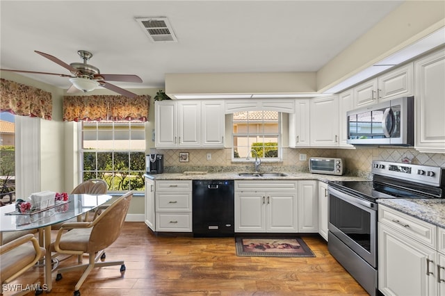 kitchen with visible vents, stainless steel appliances, decorative backsplash, and a sink