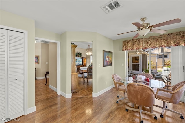 dining space with ceiling fan, wood finished floors, visible vents, and baseboards