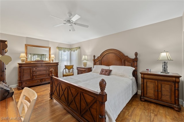 bedroom featuring ceiling fan, baseboards, and wood finished floors