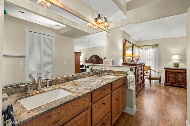 full bathroom with double vanity, hardwood / wood-style floors, ceiling fan, and a sink