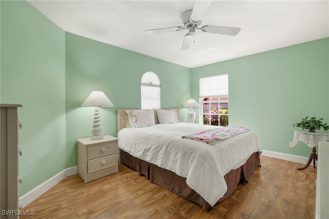 bedroom with baseboards, light wood-style floors, and a ceiling fan