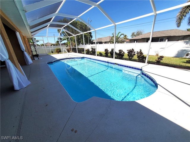 view of swimming pool featuring a fenced in pool, a patio, glass enclosure, and a fenced backyard